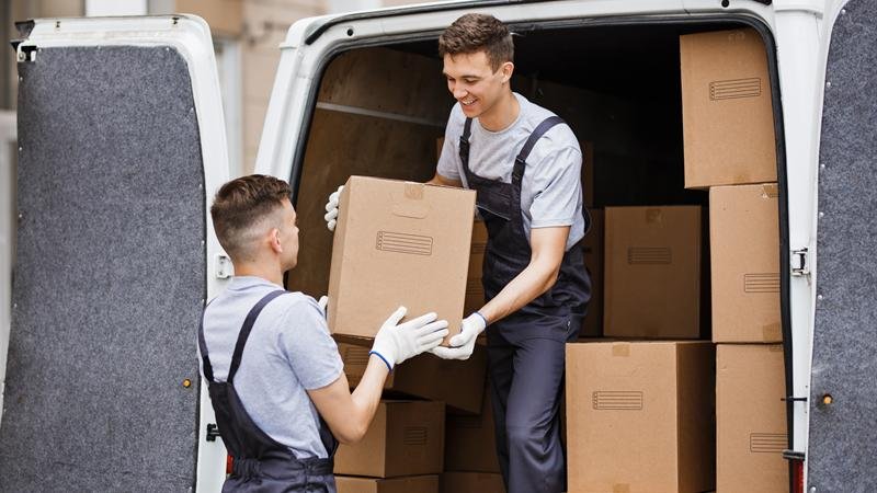 Dos operarios cargando cajas en un camión de mudanzas